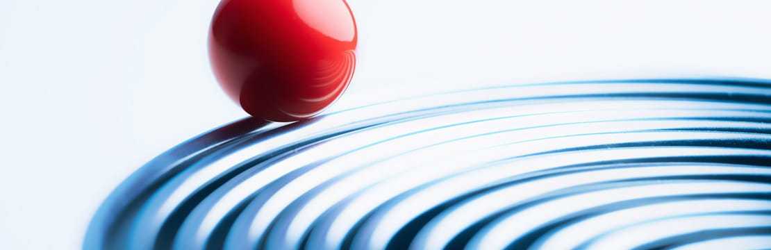 Bright red ball riding on edge of metal rings