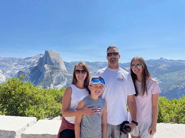 Sonia and her family posing in front of mountains