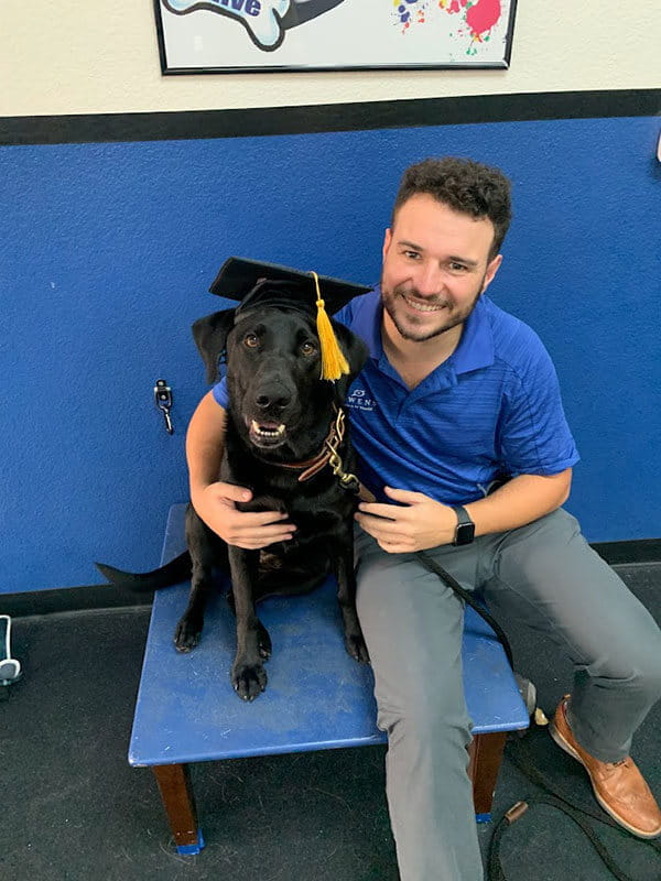 Dylan and Loki in a graduation cap